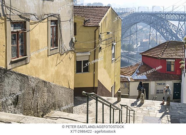 Steps leading down to the River Douro waterfront in the Ribeira district of Porto, Portugal. with the Dom Luis I Bridge in background