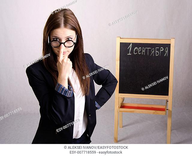 Portrait of the teacher. In the hands of the teacher's pointer. The teacher corrects points one finger. The teacher in the background stands the Board where it...
