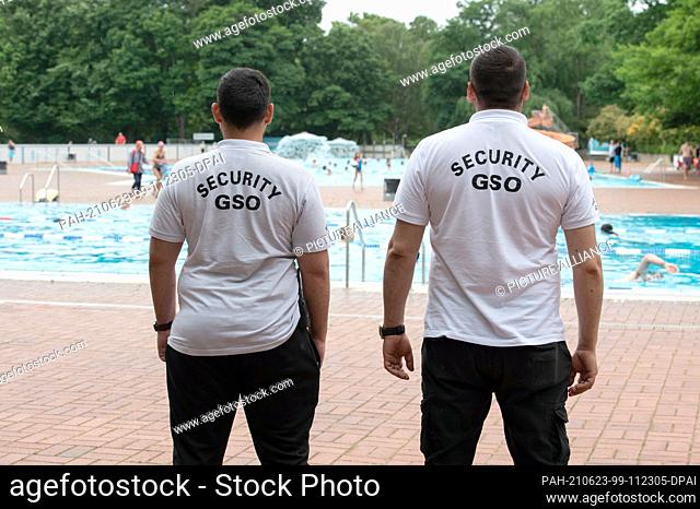 23 June 2021, Berlin: Employees of the security service ""Security GSO"" stand at the edge of the pool in the Prinzenbad