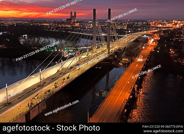 PRODUCTION - 18 December 2023, Saxony-Anhalt, Magdeburg: View of the new pylon bridge over the old Elbe at dusk (taken with a drone)