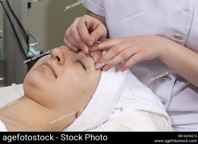 Plucking eyelashes in practical lessons. Training as a beautician at the vocational school, Düsseldorf, North Rhine-Westphalia, Germany, Europe