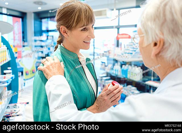 Woman customer in pharmacy buying drug hoping to get better being consoled by the chemist