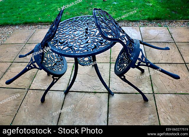 7 November 2020 - London, UK: Two garden chairs resting on matching table. High quality photo