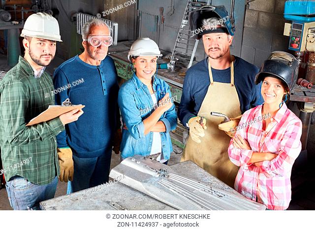 Gruppe Arbeiter als erfolgreiches Team in einem Betrieb für Metallverarbeitung