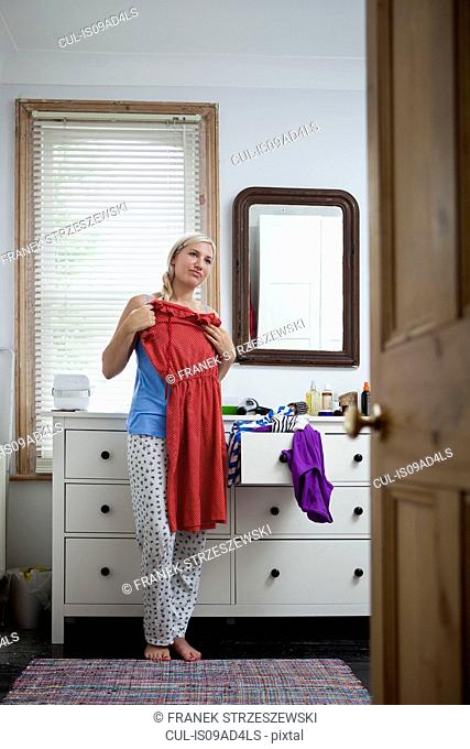 Young woman in bedroom getting ready