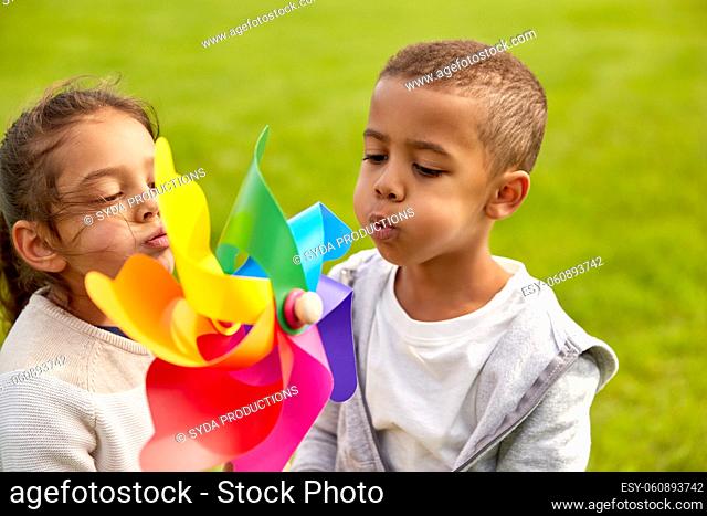 happy children playing with pinwheel at park