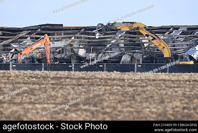 09 April 2021, Mecklenburg-Western Pomerania, Alt Tellin: A specialist company uses excavators to demolish the fire ruins of the pig breeding facility