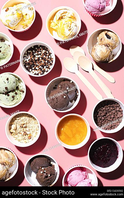 Different types of ice cream in paper cups with different toppings