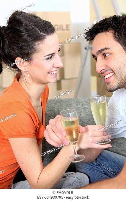 Couple celebrating moving into their new home with champagne