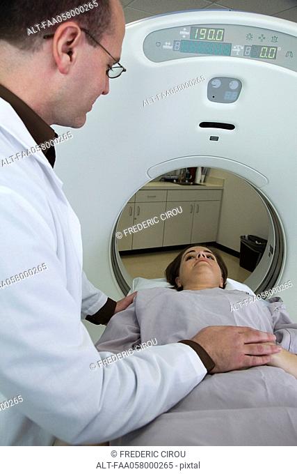 Doctor reassuring female patient preparing to undergo CAT scan