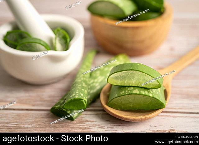 Aloe vera with slices on wooden background, medicine plant for health and beauty