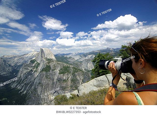 young female tourist picturing the Half Dome at the Yosemite National Park, USA, California, Sierra Nevada, Yosemite National Park