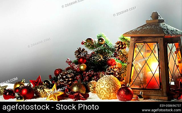 Burning candles , lantern and christmas decoration of baubles, fir branches and cones