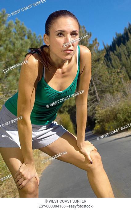 Female jogger pausing for breath on path