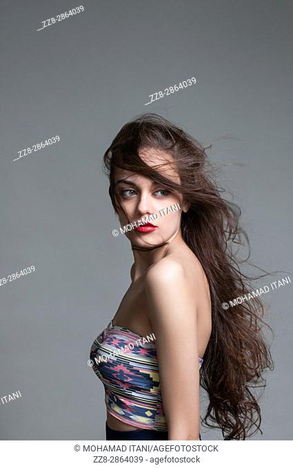 Beautiful young woman looking over shoulder hair covering face