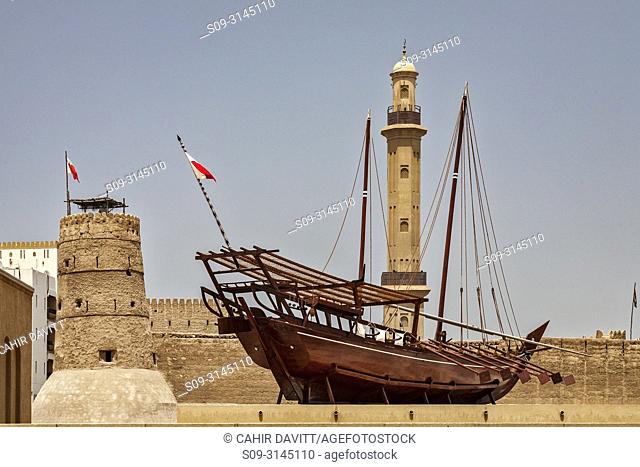 Traditional dhow ship exhibit in the Traditional Architecture Museum (Diwan) and the Minaret of the Bur Dubai Grand Mosque in the background, Bastakiya Quarter