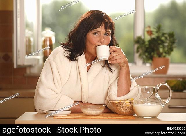 Woman at breakfast, breakfast, having breakfast, pot of milk, bowls, muesli, cup of coffee, having breakfast