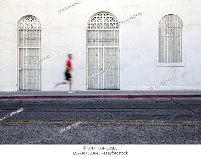 Fast paced man runs down city street