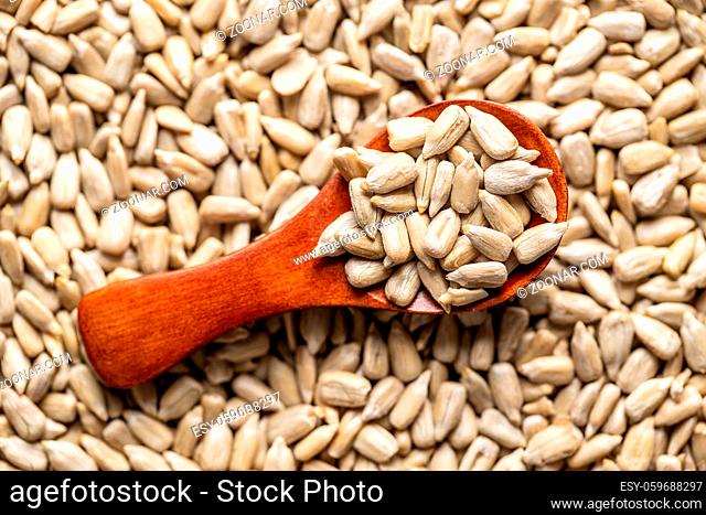 Peeled sunflower seeds in wooden scoop. Top view