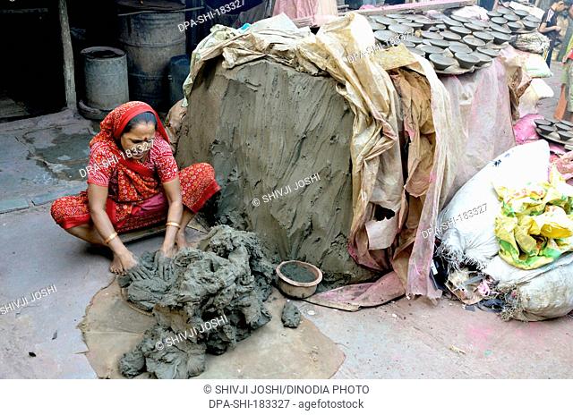 woman preparing soil for making earthen pots in Dharavi Mumbai Maharashtra India