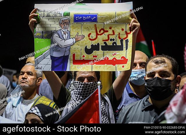 15 May 2021, Qatar, Doha: A participant holds a placard reads ""We won't leave, Jerusalem has brought us together"" during a rally in solidarity with...