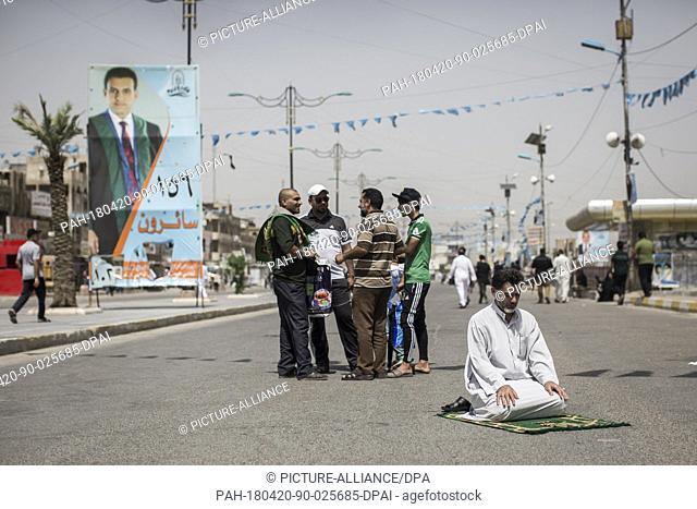 dpatop - An Iraqi man attends Friday prayers backdropped by campaign posters for the upcoming parliamentary elections in the Sadr City suburb of Baghdad, Iraq