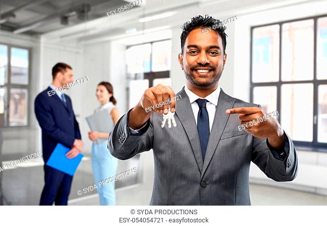 indian man realtor with keys at empty office room
