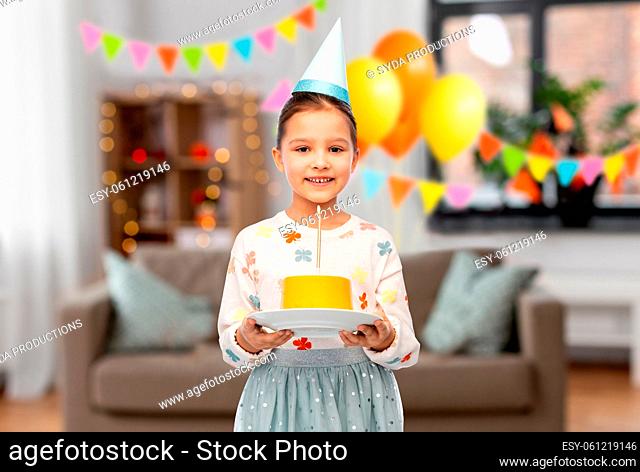 smiling girl in party hat with birthday cake