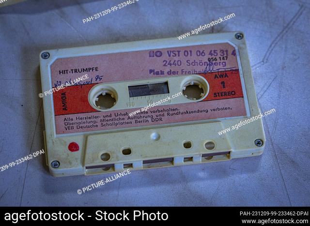PRODUCTION - 28 November 2023, Mecklenburg-Western Pomerania, Schwerin: A music cassette with ""hit trump cards"" from the GDR music publisher AMIGA lies in a...