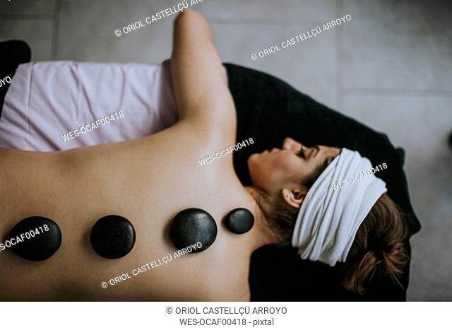 Young woman with heated stones on her back