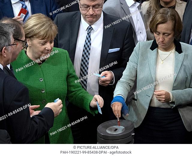 21 February 2019, Berlin: Federal Chancellor Angela Merkel (CDU, l) and Beatrix von Storch (AfD), MPs, will hand in their voting cards during the 83rd session...