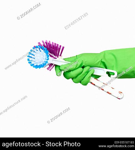 white plastic cleaning brushes in hand, protective green glove on hand, white background