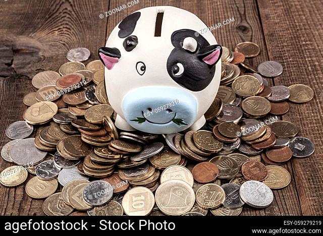 Piggy bank and coins on wood table