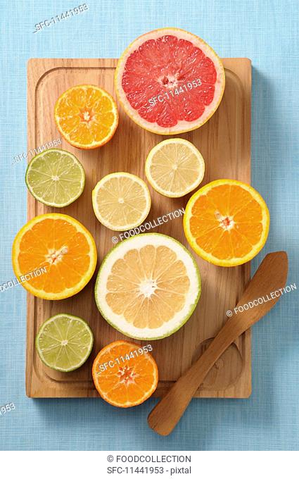 Halved citrus fruits on a wooden board