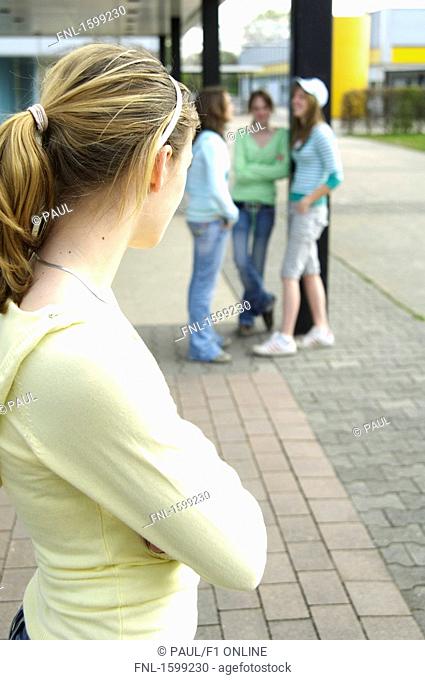 Side profile of teenage girl looking at her friends