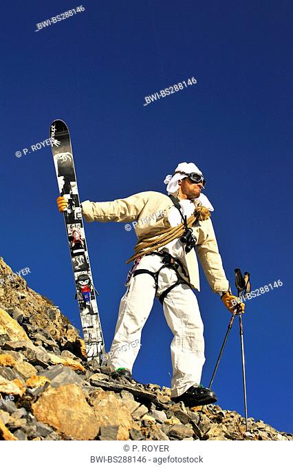 freeride skier disguised as oldfashioned adventurer standing on rocky slope