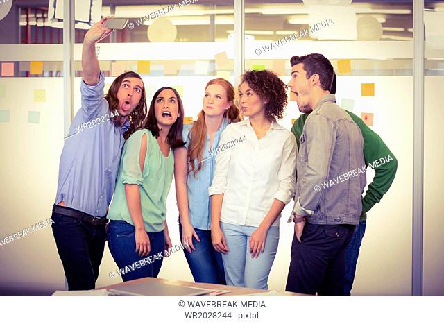 Creative businessman taking selfie of colleagues