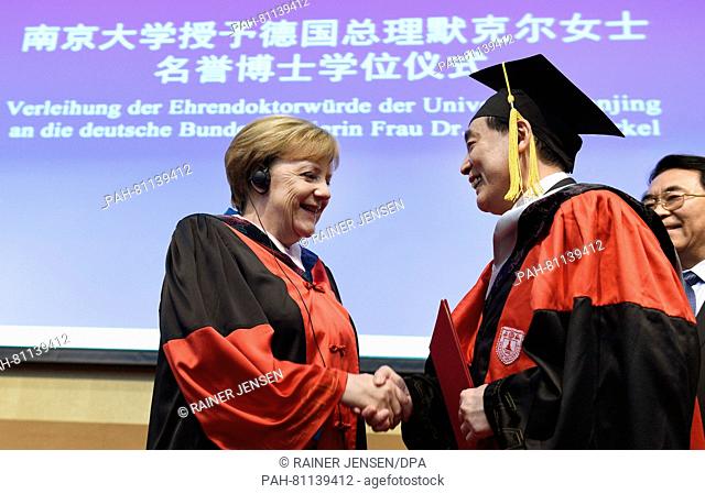 German Chancellor Angela Merkel (L) receives an honorary doctorate from the University of Nanjing from laudator, professor Chen Jun (2-R)