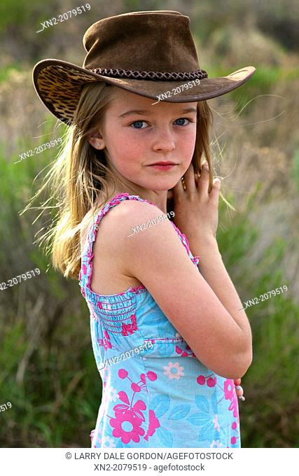 Young girl in the country wearing cowboy hat