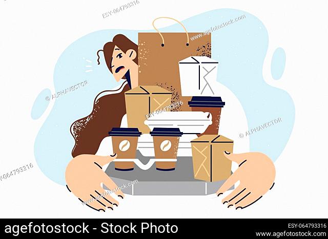 Woman holds boxes and bags for take-out food working as delivery courier at fastfood restaurant. Courier girl with embarrassed emotions showing paper containers...