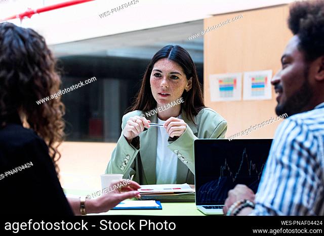 Businesswoman listening to colleague during a meeting in office