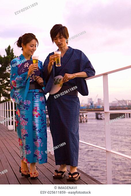 Couple in yukatas holding beers