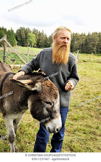 Philippe Demoisson, farmer and gatherer of aromatic and medicinal herbs in the village of Saint-Bonnet-le-Bourg, with a donkey