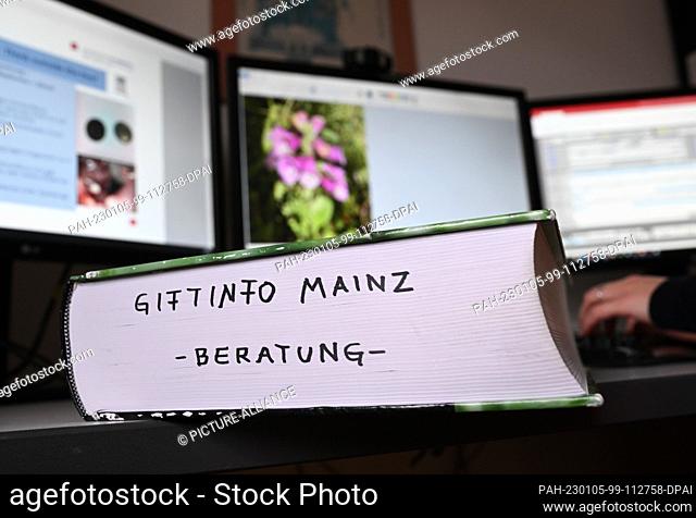 05 January 2023, Rhineland-Palatinate, Mainz: A book with the inscription ""Giftinfo Mainz - Beratung"" is placed in front of a consultant of the Poison...
