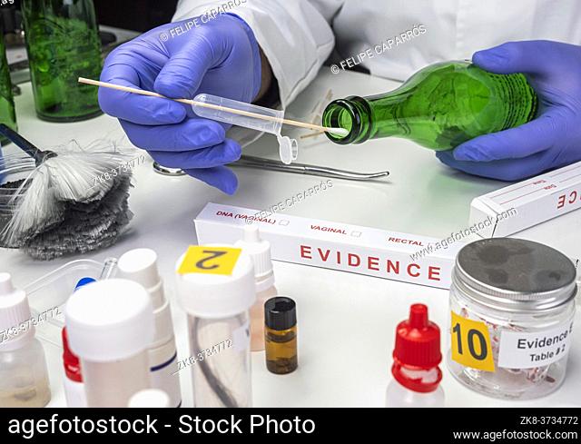 Police expert gets blood sample from a green glass bottle in Criminalistic Lab, conceptual image