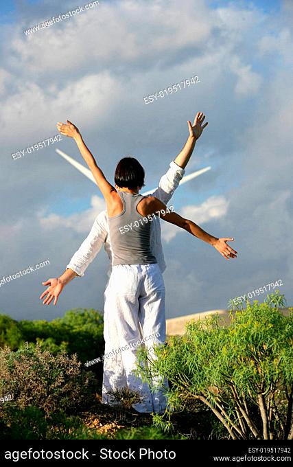 Man and woman lifting arm near a wind back