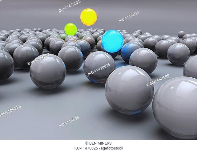 Glowing colorful balls among grey balls