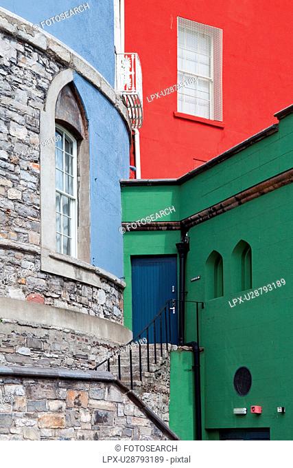 Detail view of south facade of Dublin Castle, with different areas painted green, blue, red, against grey Norman stone of original fortifications, Dublin