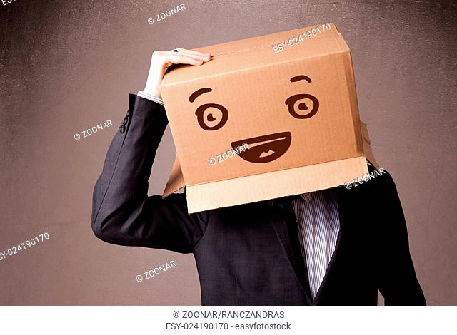 Businessman gesturing with a cardboard box on his head with smiley face
