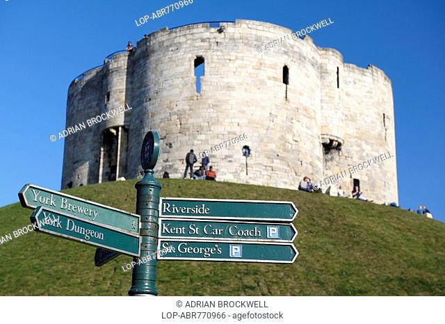 England, North Yorkshire, York, Clifford's Tower, one of the principal remains of York castle, with a tourist sign post in the foreground